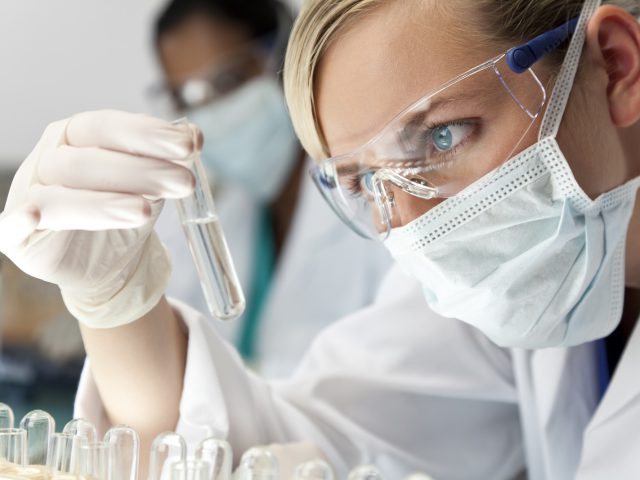 Female Scientific Research Team With Clear Solution In Laboratory